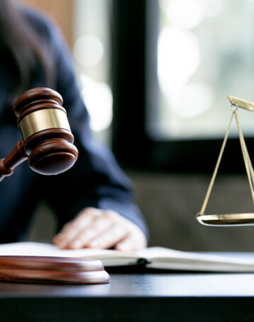 justice and law concept.Female judge holding wooden gavel in a c justice and law concept.Female judge holding wooden gavel in a courtroom on wooden table