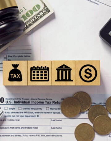 Tax concept.Tax icon on wooden block.Calculator with money on 1040 tax form.Income tax return.