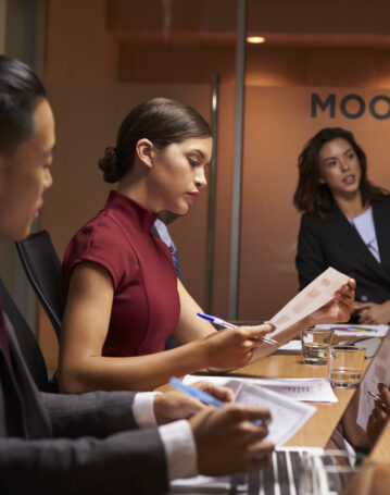 Female boss chairing business meeting in boardroom, close up